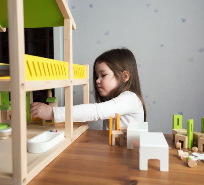 A little girl plays with toys in an individual therapy for children setting.