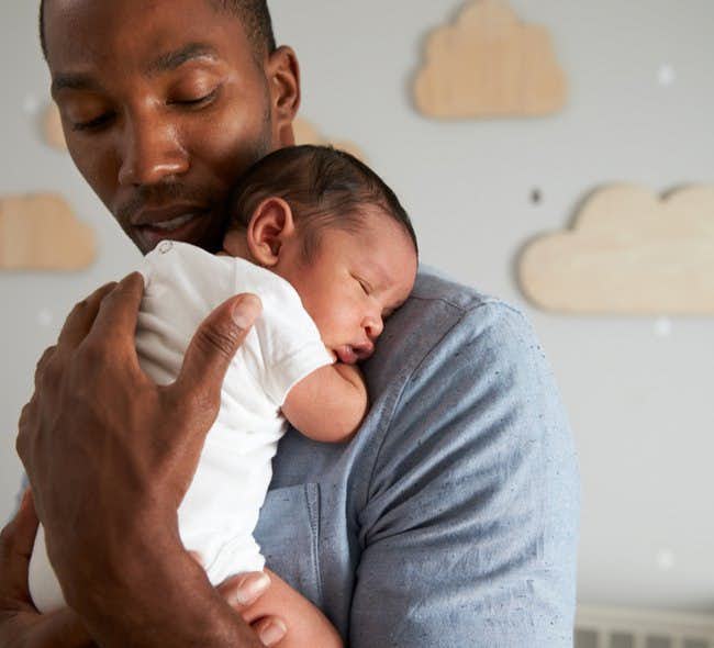 A new father holds his infant child.