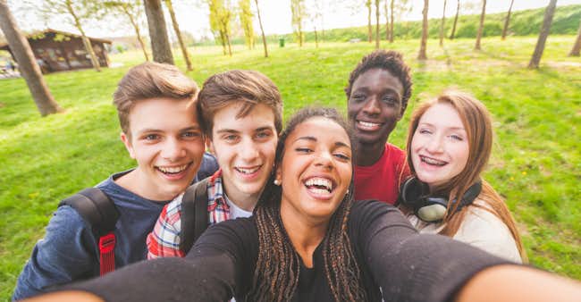 A group of teens smile together.